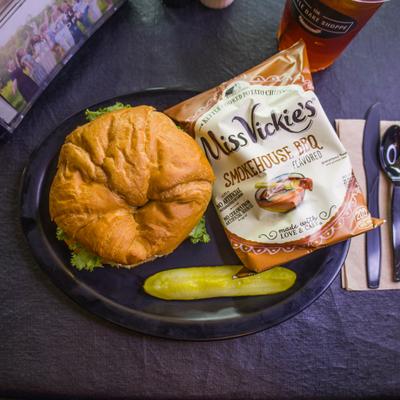 Chicken Salad and Cheese sandwich with sides of chips and a pickle spear.