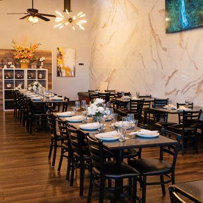 Dining read, different size tables decorated and set with tableware.