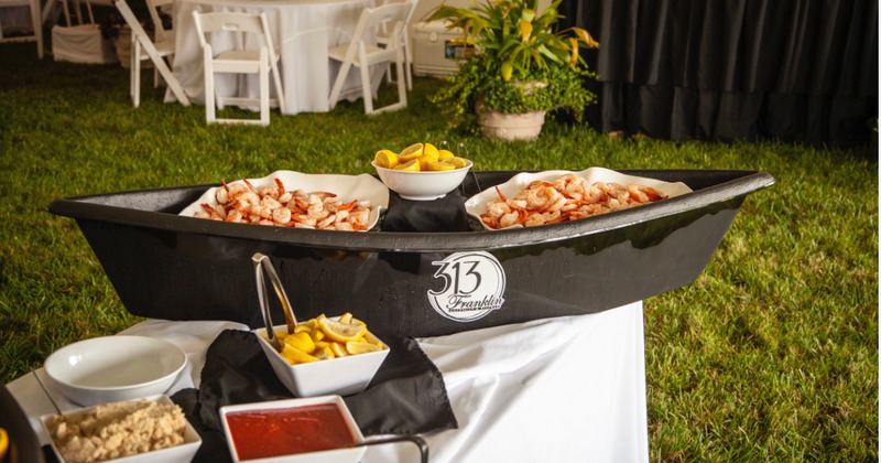 Fresh shrimp, lemons, & tangy cocktail sauce on an outdoor table