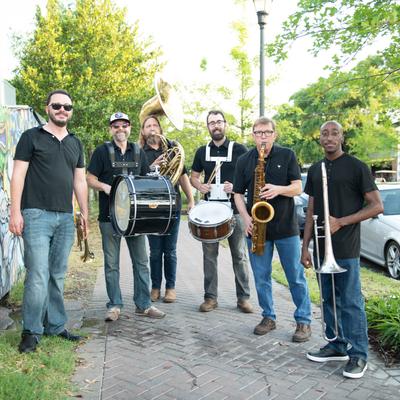 Outside, brass band posing for a photo portrait.