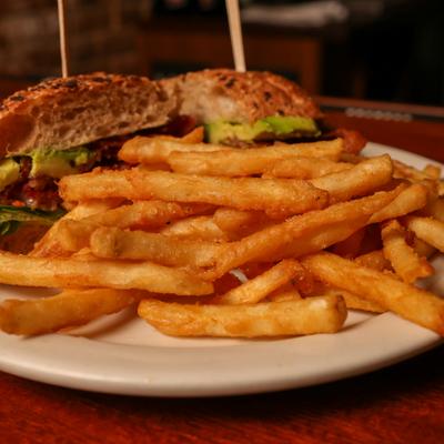 Avocado and BLT sandwich, with fries.