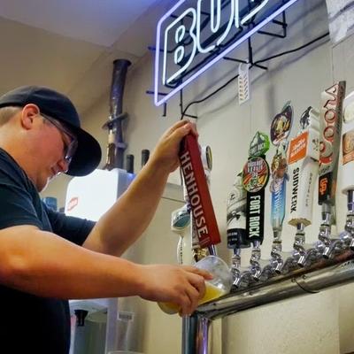A person pouring beer from the dispensary.
