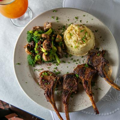 Rack of Lamb with mashed potatoes, broccoli, and mushrooms.