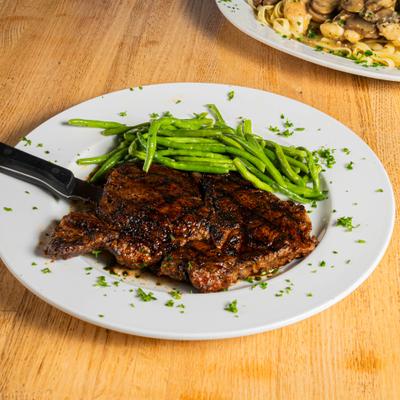 Espresso-rubbed ribeye steak served alongside green beans.
