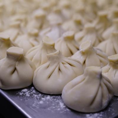 large tray of khinkali - Georgian soup dumplings - ready to be cooked