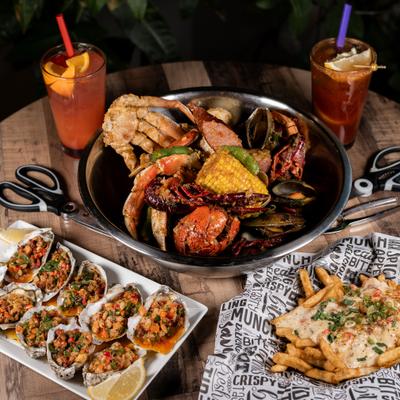 Cajun-style seafood boil feast alongiside cocktails and appetizers.