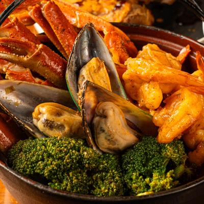 Cajun-style seafood boil featuring snow crab legs, mussels, shrimp and broccoli.