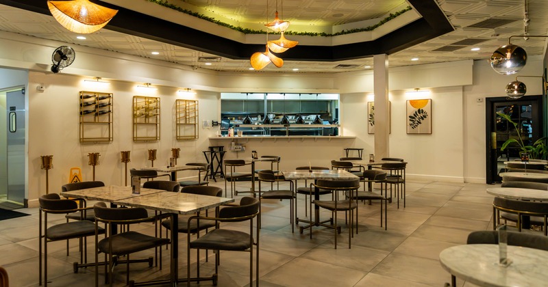 Interior, dining area, tables for six, four and two, kitchen counter in the back