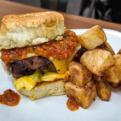 Breakfast biscuit sandwich and fried potato puffs.