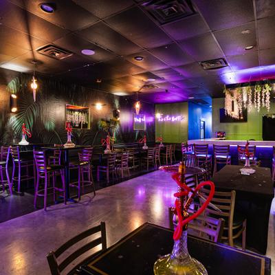 Interior with a mix of high-top and regular tables with hookah setups.