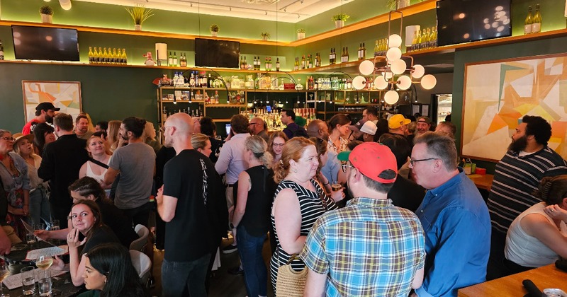 Crowded bar with people mingling and chatting