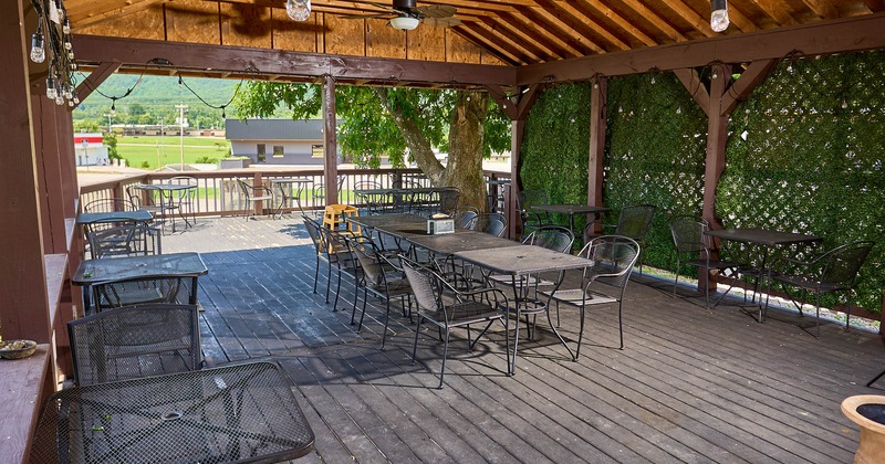 Exterior, patio, partially covered seating area, metal tables and chairs, wooden deck