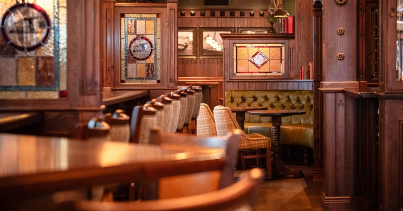 Interior, closeup on a corner seating area and bar stools, engraved wood interior details