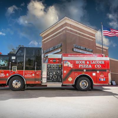 Hook and Ladder Pizza Co fire truck promotional vehicle parked at Devivo Bros Eatery.