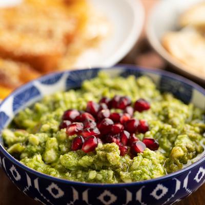 Cretan Paste topped with fresh pomegranate seeds, close-up.