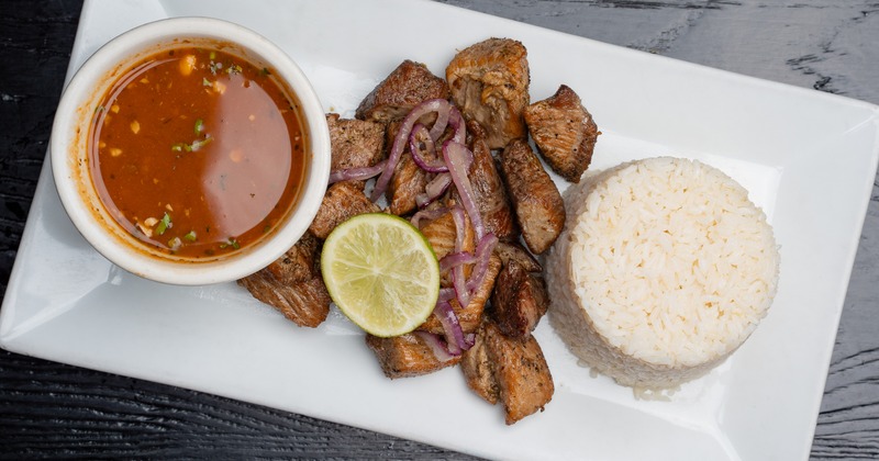 Fried beef topped with grilled onions, served with rice and a bowl of broth