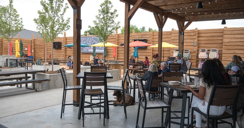 A partially covered patio, guests chatting and enjoying their drinks