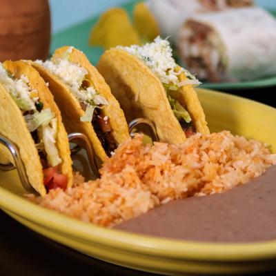 Tacos with a side of rice and refried beans.