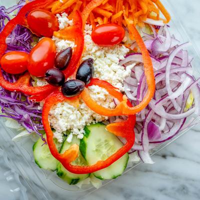 Greek salad with feta, cucumbers, onions, olives, cherry tomatoes and peppers.