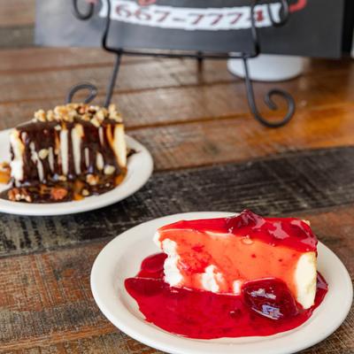 Strawberry Cheesecake and Turtle Cheesecake, plated and served.