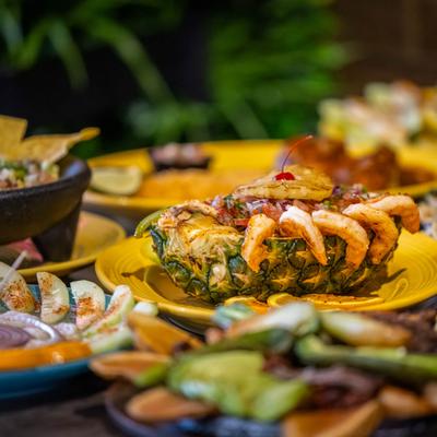 Shrimp pineapple bowl and other dishes on a table.