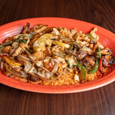 Chicken  fajitas served over a bed of Mexican red rice.