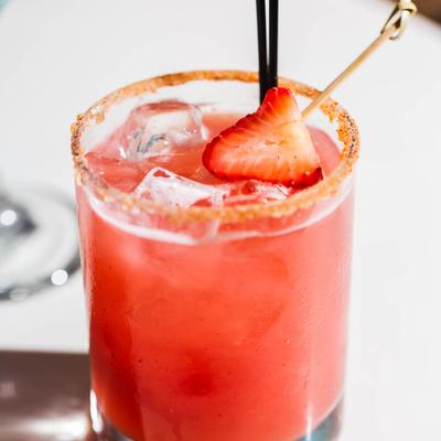 Refreshing red That's Spicy Cocktail with chili salt rim and a strawberry.