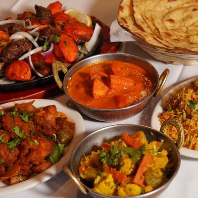 A variety of food dishes spread on a white tablecloth.