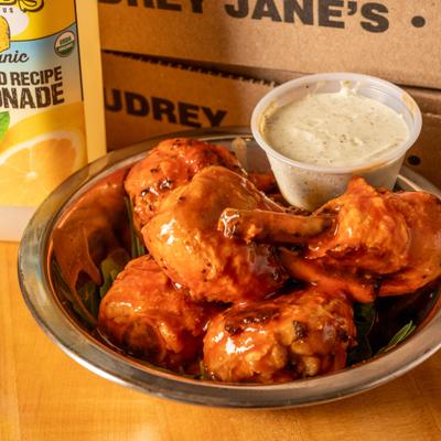 Buffalo chicken wings served in a metal bowl with dipping sauce.