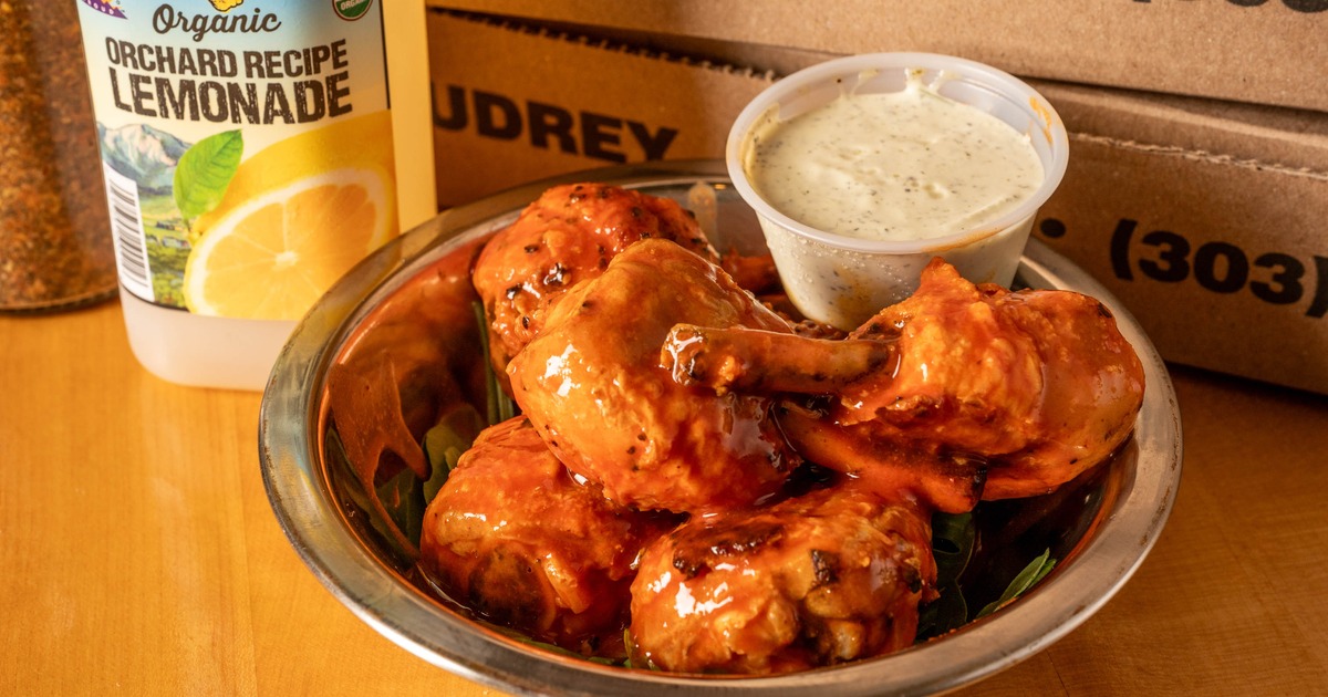Crispy buffalo chicken lollipops served in a bowl with creamy dipping sauce