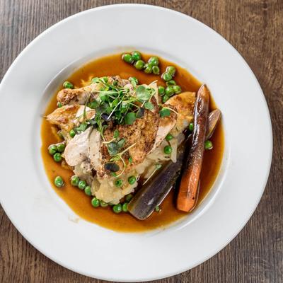 Roasted chicken with mashed potatoes, carrots, peas, and greens.