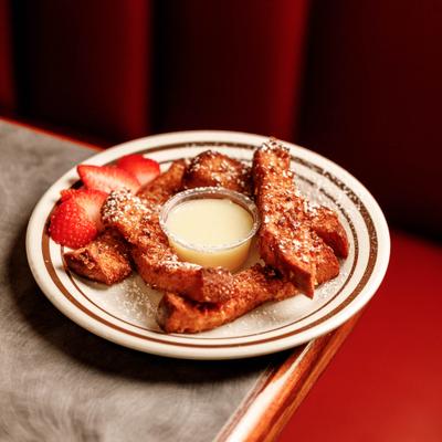 French toast sticks served with strawberries and sauce.