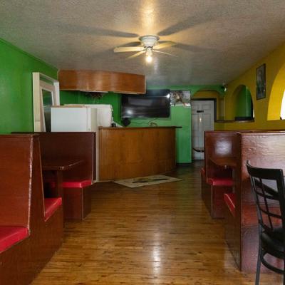 Dining room with green walls, wooden boots and a counter area.