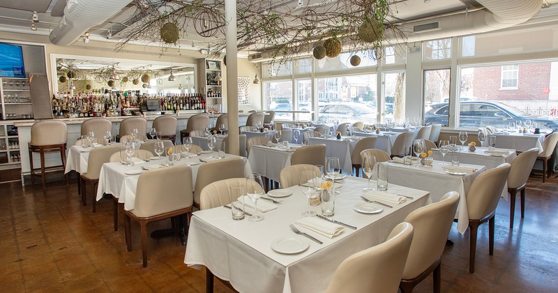 Spacious and cozy interior dining area with elegantly decorated and set dining tables