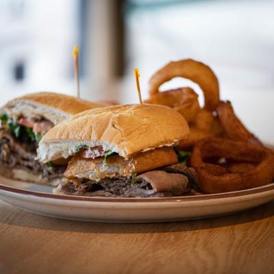 Silver State Sizzle Steak Sandwich with a side of onion rings.