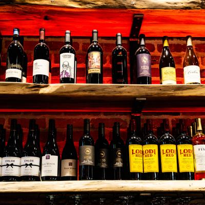 View at the wine numerous bottles on wooden shelves.