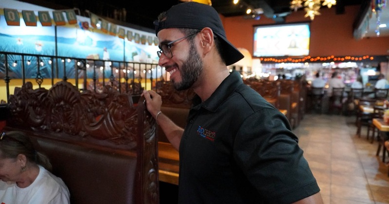 A smiling staff member checking up on guests