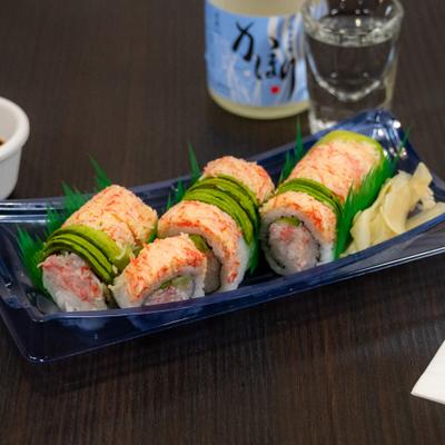 Chef Special Roll served with dipping sauce and sake.