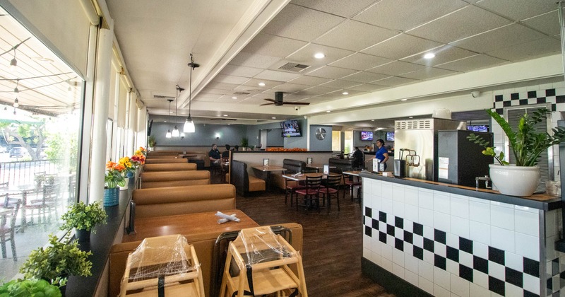 Interior, booth seating, checkered counter, and windows showcasing an outdoor seating area