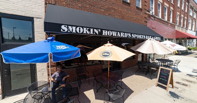 Exterior, entrance and patio in front with tables and chairs, parasols