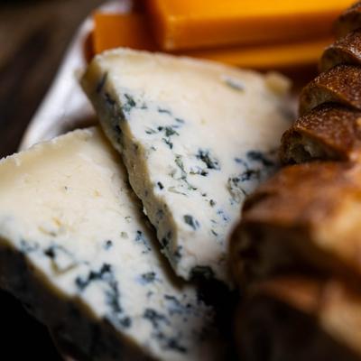 Close-up of blue cheese wedges beside bread slices.