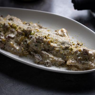 Beef stuffed ravioli with a pistachio infused sauce, diced filet mignon, and cream.