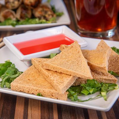 Fried tofu with a side of bright red dipping sauce.