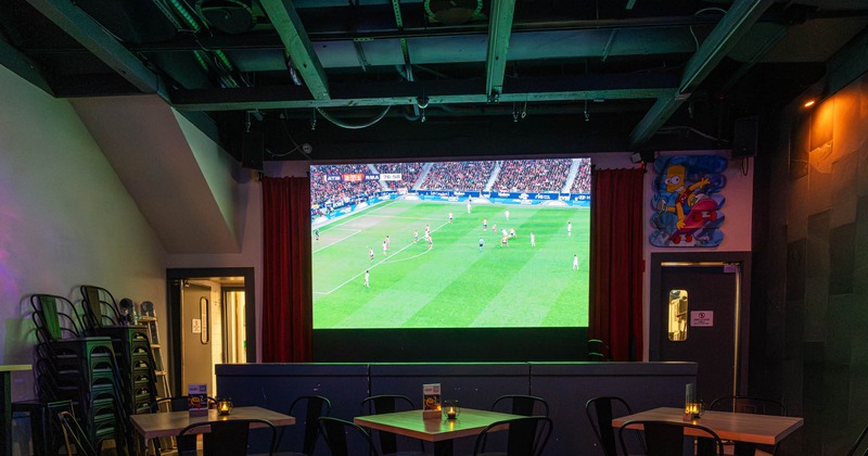 Interior, guest tables and chairs, wall TV screens
