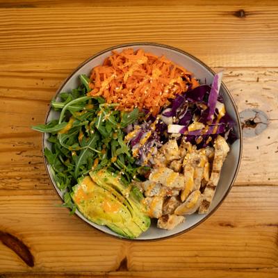 Overhead view of Kickin Chicken grain bowl on a wooden table.