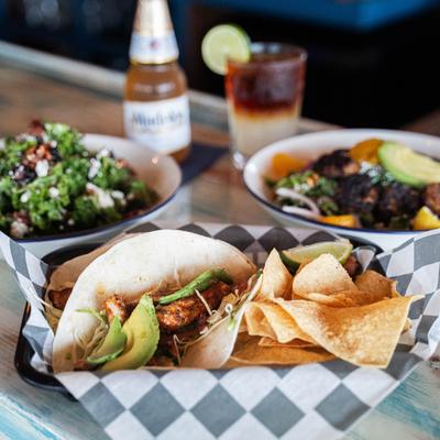 Tuna mahi tacos with multiple dish plates and drinks.