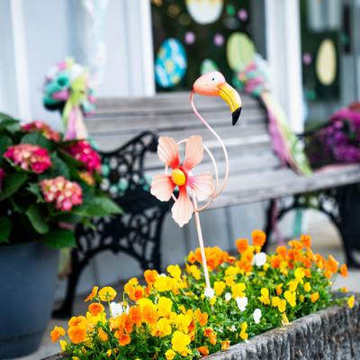 Exterior, outdoor seating with flamingo-themed garden decorations and flowers.