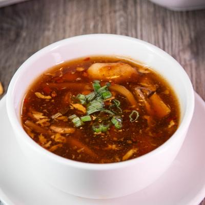 Hot and sour soup garnished with herbs.