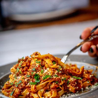 A hand sticking a fork into Tagliatelle.