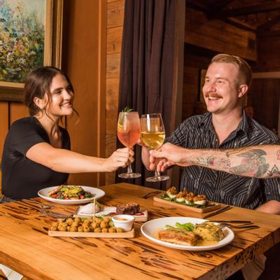 Customers clinking glasses at table with served food